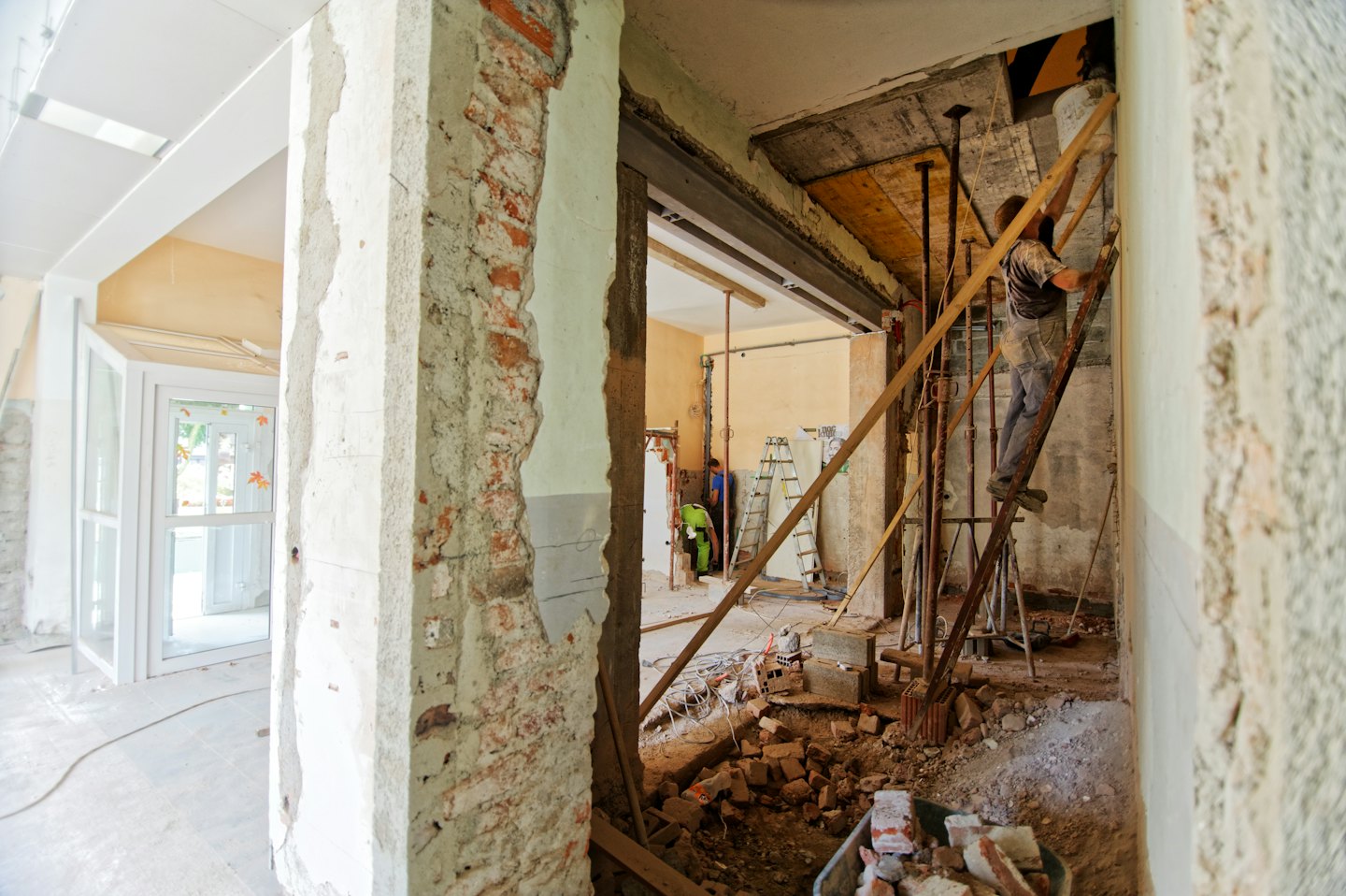Bouwvakkers die een gebouw met zichtbare bakstenen muren renoveren.